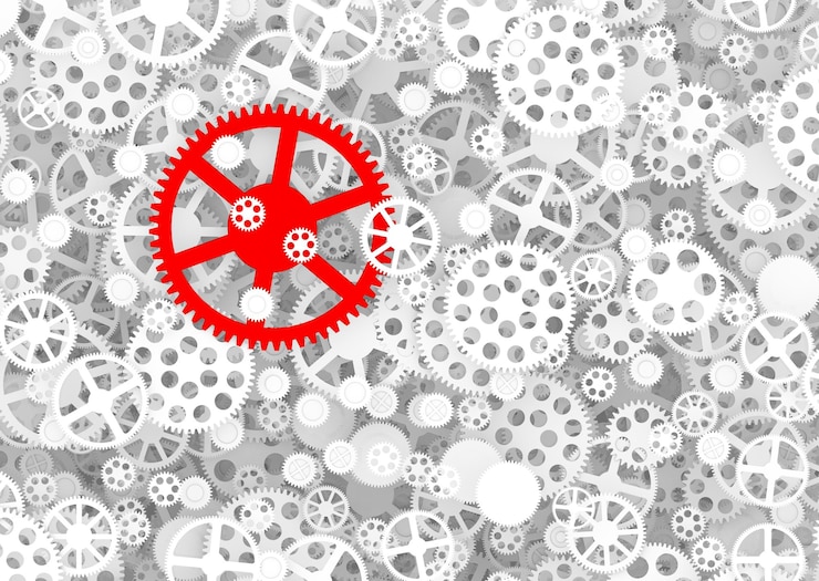 Photo red gear among white gears