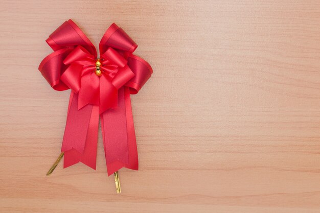 Red gift bow ribbon on wooden table