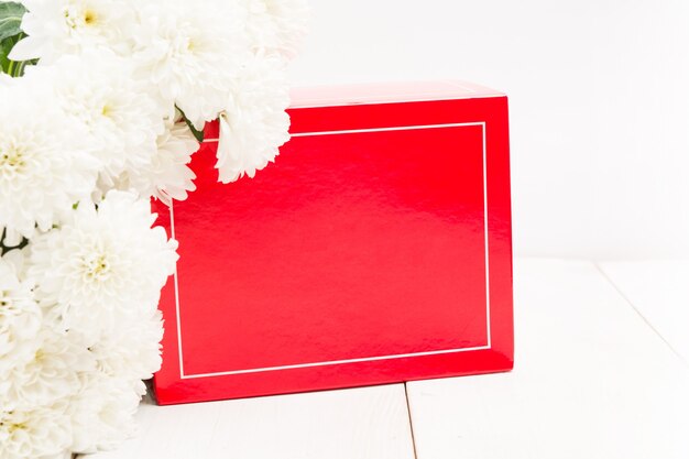 Red gift box and bouquet of white flowers