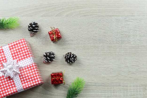 Red gift box for Christmas decoration on wooden floor.