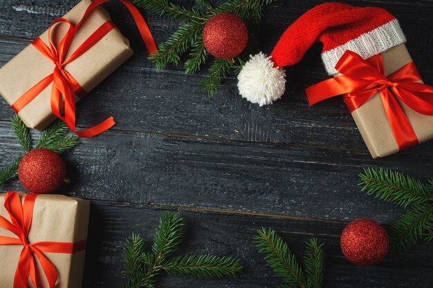 나무 테이블 배경에 산타 모자에 크리스마스를위한 빨간 선물 상자