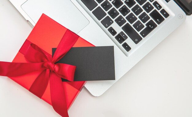 Red gift box and computer laptop on white background top\
view