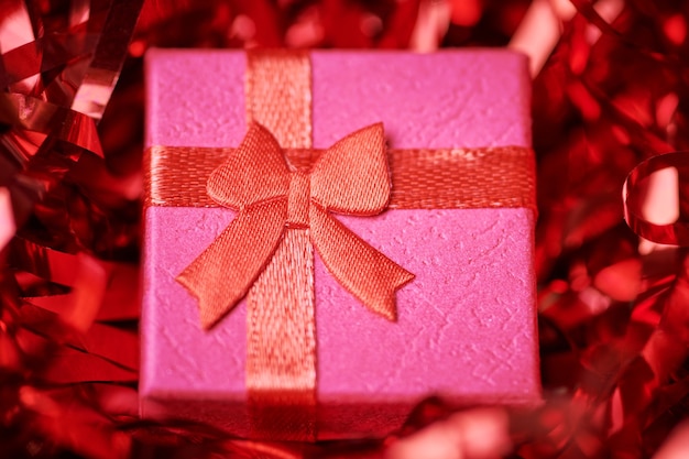 Red gift box in festive tinsel