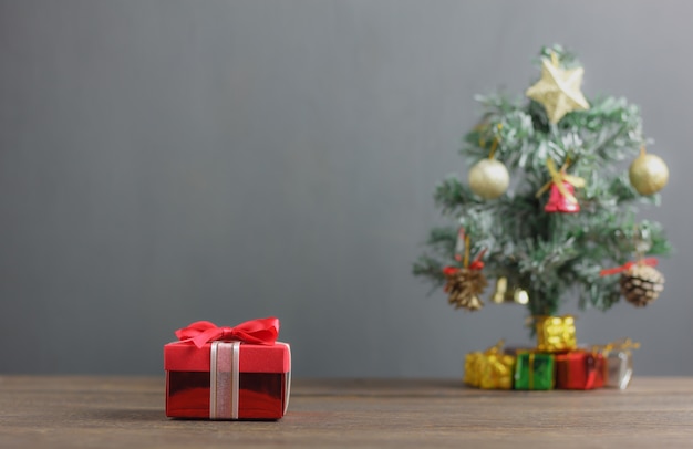 Red gift box and fir tree background.