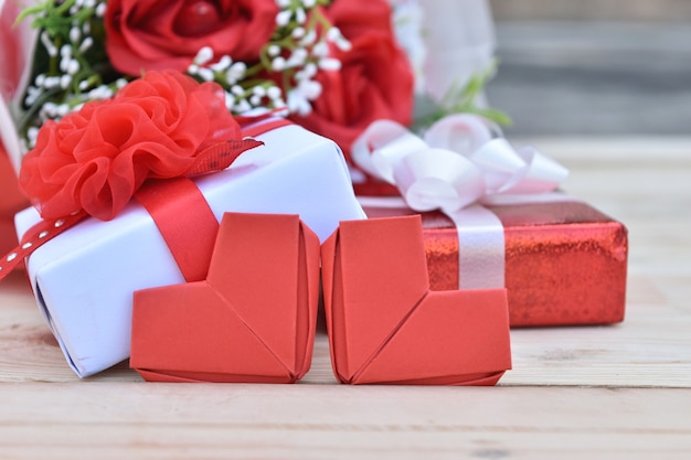 Confezione regalo rossa e a forma di cuore su legno