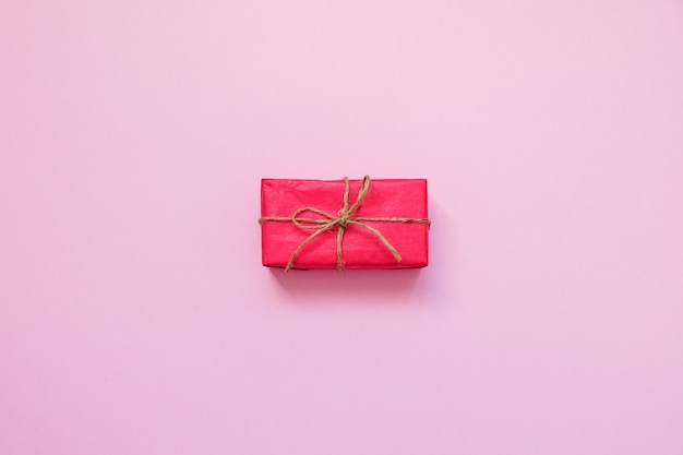 Red gift box on pink background. 