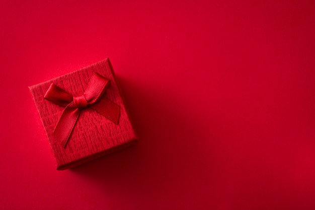 Red gift box on red background with copy space