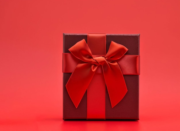 red gift box on red ribbon and red background white