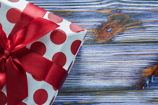 Red gift box on vintage wooden board front view