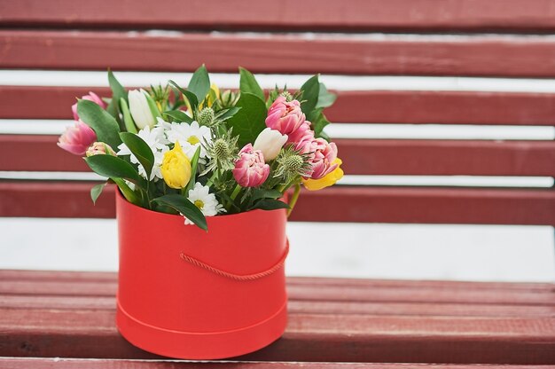 Photo red gift box with beautiful bouquet symbol of romantic momen