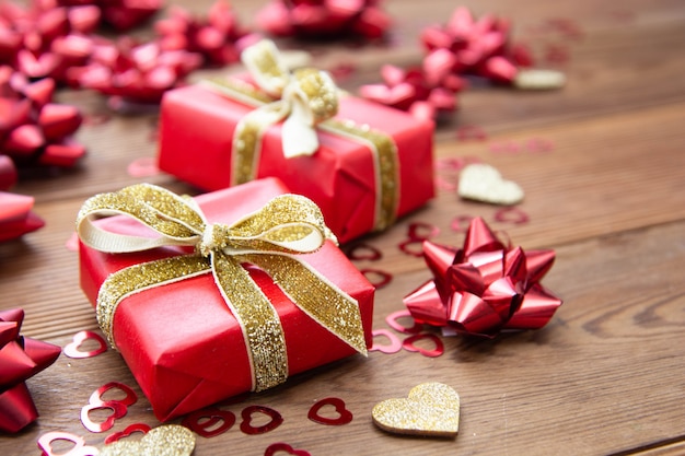 Red gift box with bows, on wooden table. Copy space. Valentine's day, birthday, Christmas.