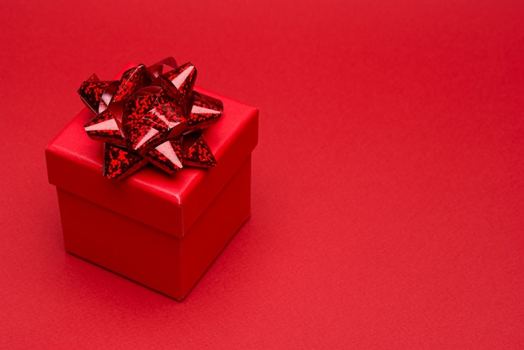 Photo red gift box with colored ribbon on red