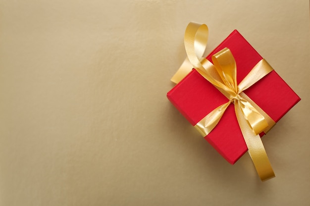 Red gift box with gold ribbon and bow
