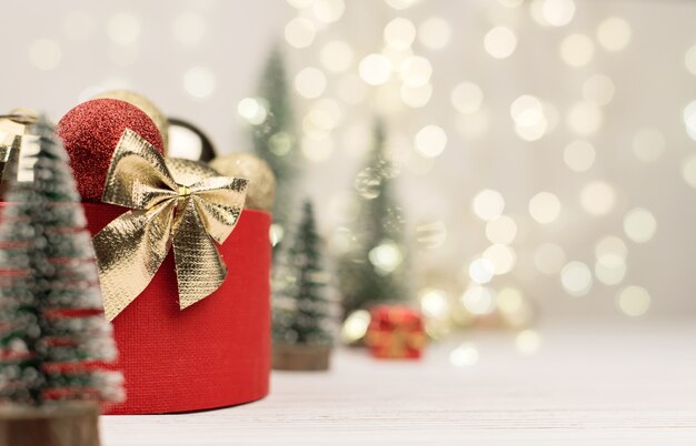 red gift box with a Golden bow with christmas trees