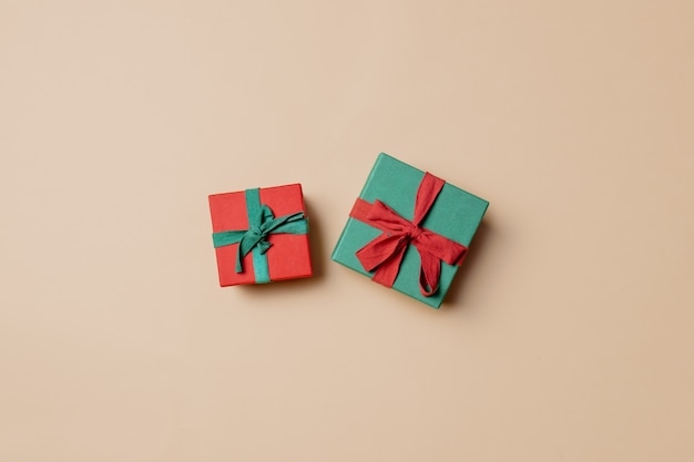 Red gift box with green ribbon and green with red on stark white background. Above view