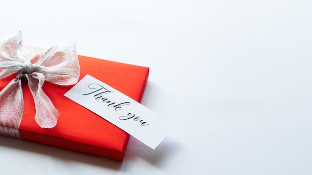 Photo a red gift box with grey tape and a note with message