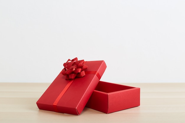 사진 빈티지 화이트 나무 테이블에 열린 리본 활과 빨간색 선물 상자