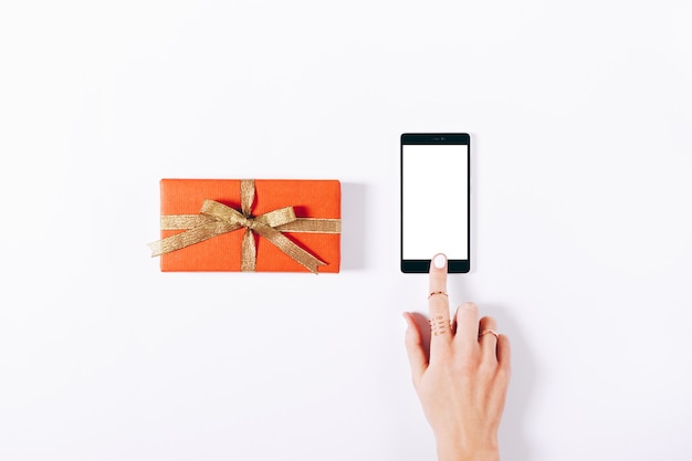 Red gift box with ribbon and mobile phone