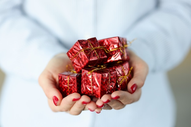 Red gift boxes in female hands