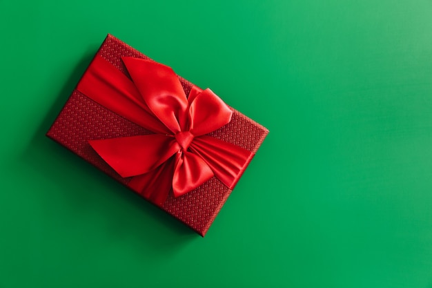 Red gift boxes on green background. Christmas card. Flat lay. Top view with space for text.