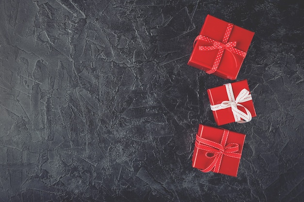 Red gift boxes tied with ribbons with bows and decorative silk hearts. Flat lay. Top view.