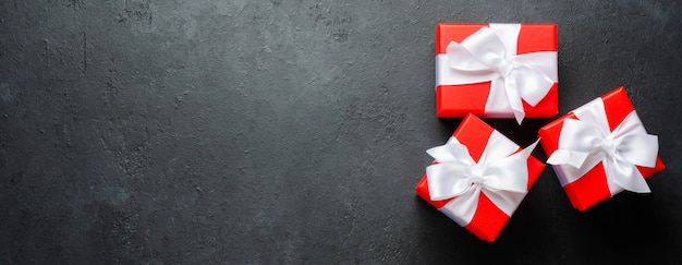 Red gift boxes with white ribbons on black background