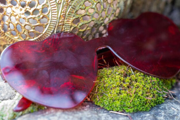 Red glasses in the form of hearts on a natural background