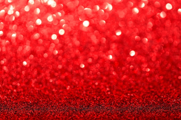 Red glitter foil Christmas background. Shiny metal red foil texture abstract defocused background. Sparkle glitter texture with bokeh lights.