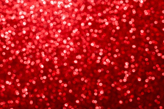 Red glitter foil Christmas background. Shiny metal red foil texture abstract defocused background. Sparkle glitter texture with bokeh lights.