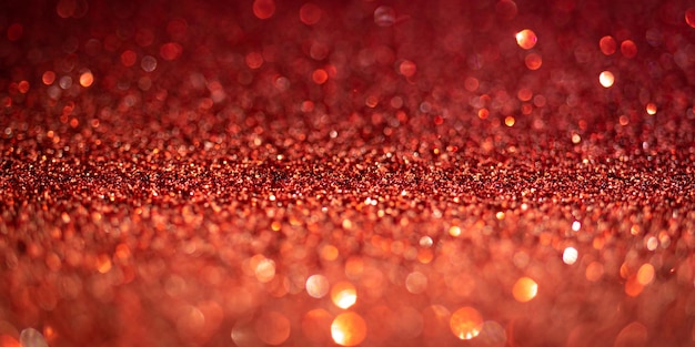 Red glitter lights. Shiny sparkles, bokeh effects, glowing surface. Selective focus, christmas abstract banner, background photo