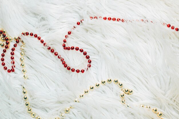 Red and gold beads on a fluffy white background.