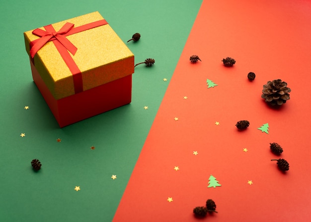 별 원뿔과 작은 크리스마스 트리가 있는 밝은 배경에 빨간색과 금색 선물 상자