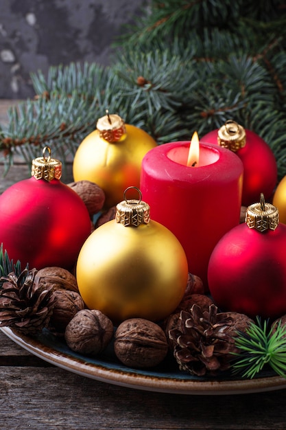 Red and golden Christmas balls on plate. Selective focus