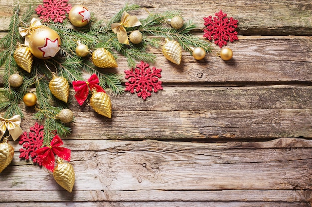 Красные и золотые рождественские украшения на деревянном фоне