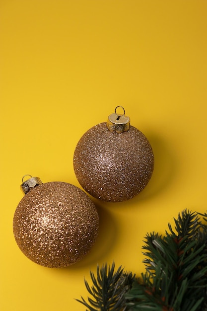 red and golden Christmas ornament balls on yellow background. Flat lay, top view, copy space