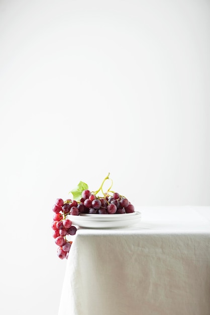 Red grape on the white linen tablecloth