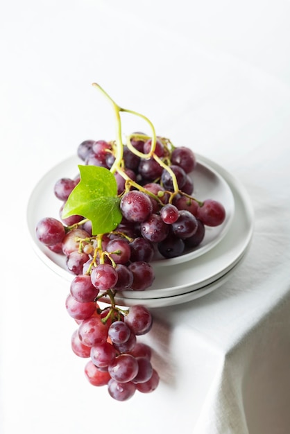 Red grape on the white linen tablecloth