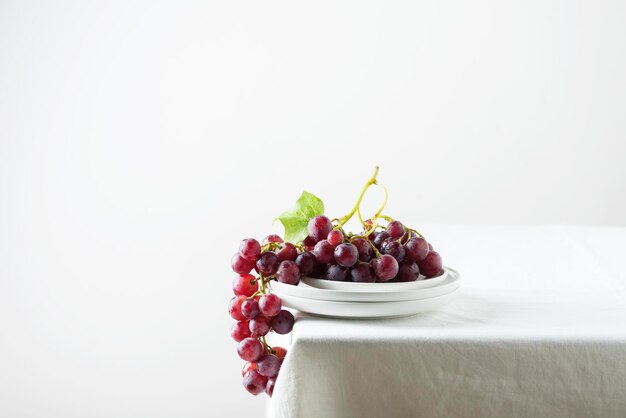 Red grape on the white linen tablecloth