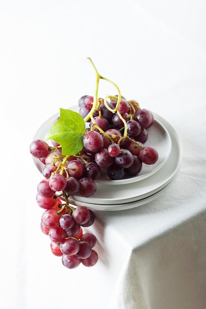 Red grape on the white linen tablecloth