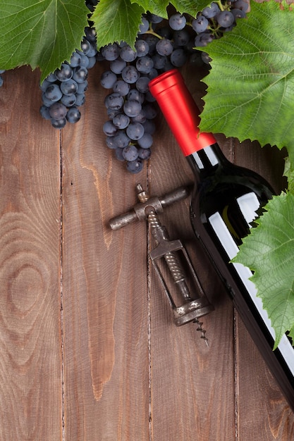 Red grape wine bottle and corkscrew