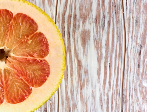 Photo red grapefruit half on a wooden background with copy space