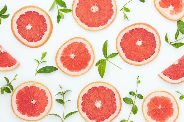 red grapefruits and green leaves on the gray surface