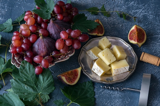 red grapes, figs, cheese, corkscrew and cork from wine and around the vine