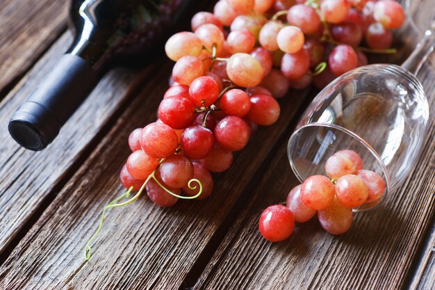 Red grapes, glass, bottle of red wine, cork and corkscrew 