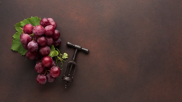 Photo red grapes and wine corkscrew
