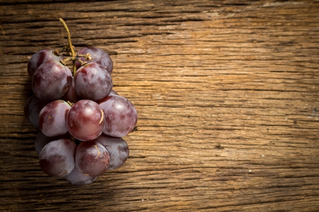 Red grapes on wooden table 