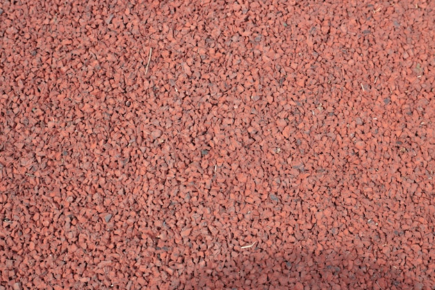 A red gravel surface is shown on a black background.