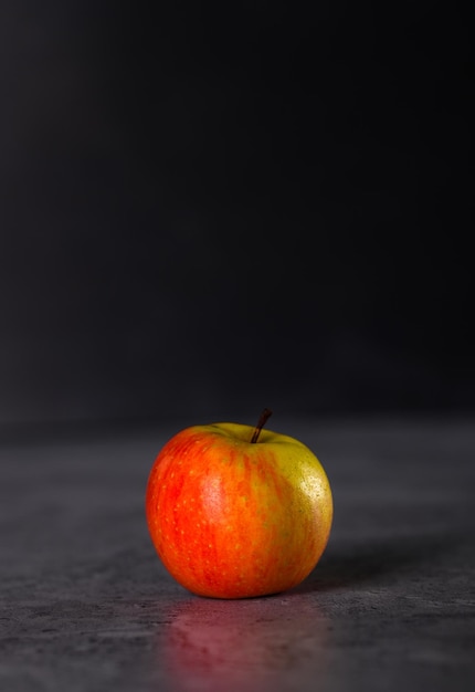 Красное и зеленое яблоко изолировано на темном фоне