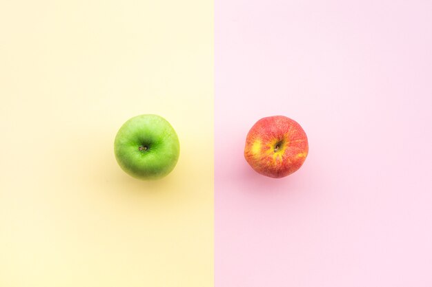 red and green apple on pastel desk