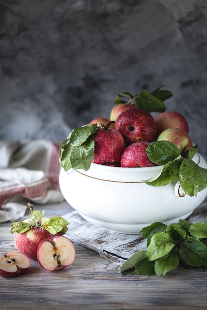 Red and green apples in a white ceramic bowl